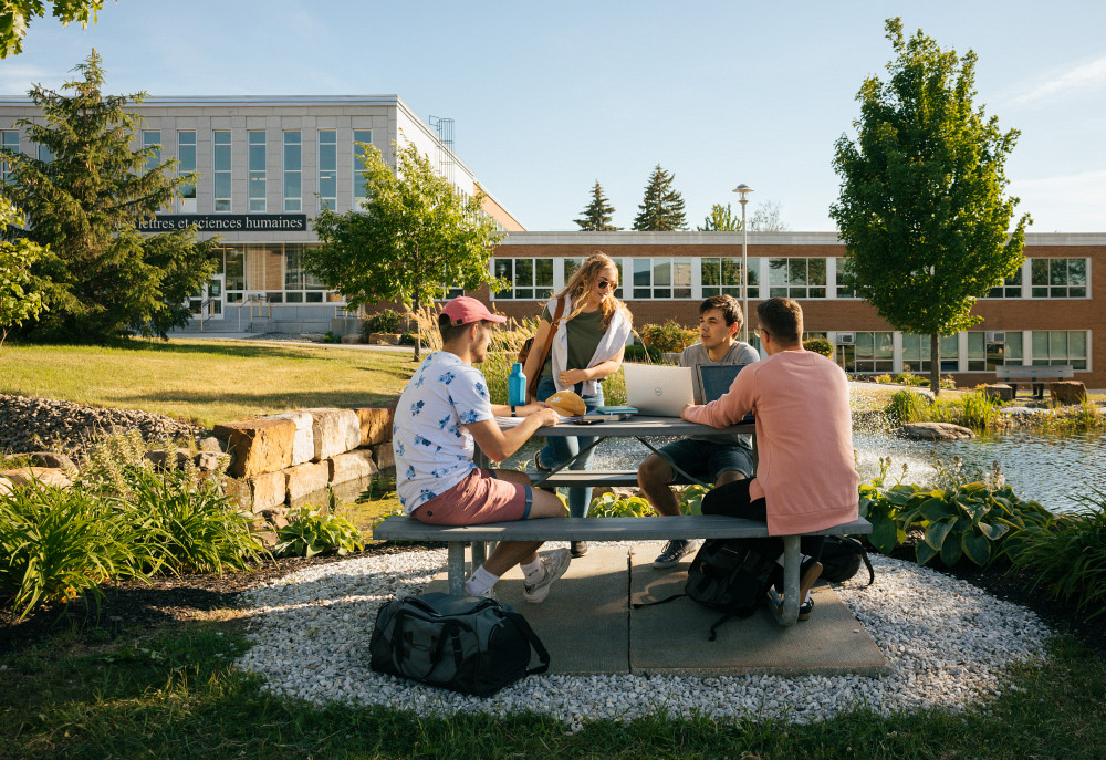Des personnes &eacute;tudiantes devant la Facult&eacute; des lettres et sciences humaines de l'Universit&eacute; de Sherbrooke.