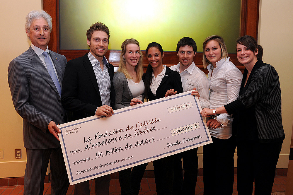 Le pr&eacute;sident de la FAEQ remet un ch&egrave;que de 1&nbsp;M$ en pr&eacute;sence de 6&nbsp;m&eacute;daill&eacute;es olympiques aux Jeux de Vancouver&nbsp;: Fran&ccedil;ois-Louis Tremblay, Marianne St-Gelais, Kalyna Roberge, Alexandre Bilodeau, Marie-Philip Poulin et Catherine Ward.