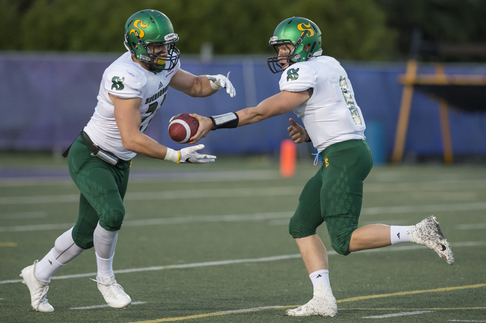 Le porteur de ballon Gabriel Polan et le quart-arri&egrave;re Alex Jacob-Michaud.