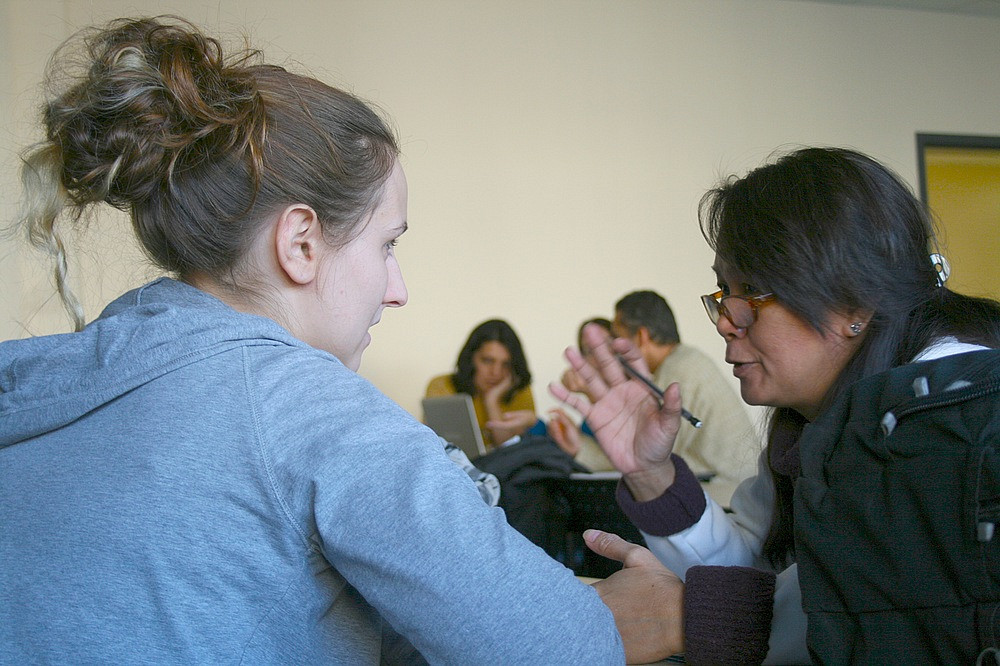 Une étudiante en écologie internationale de l'UdeS discute avec une immigrante du programme de francisation.