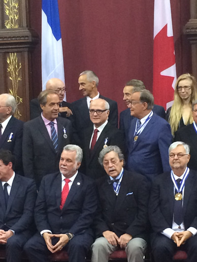 Pr Paul Grand'Maison derri&egrave;re le Premier ministre, Philippe Couillard avec d'autres r&eacute;cipiendaires.