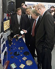 Quelques dignitaires, dont le premier ministre Jean Charest, découvrent des produits de la microélectronique lors de l'annonce de la création du futur centre de recherche.