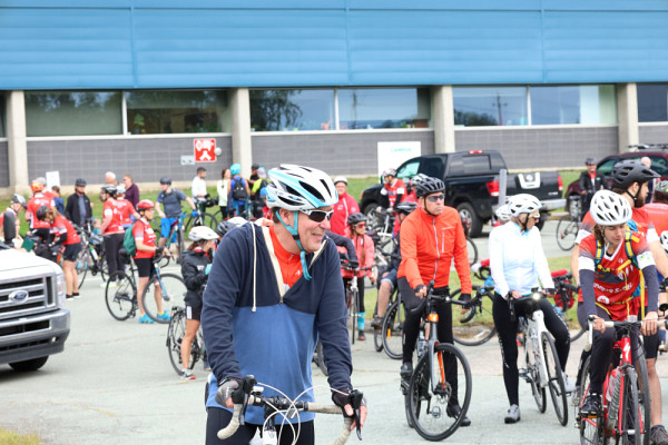 Jean-Pierre Perreault, vice-recteur de l'Université de Sherbrooke, entouré des participants cyclistes prêts à partir pour réaliser leur défi