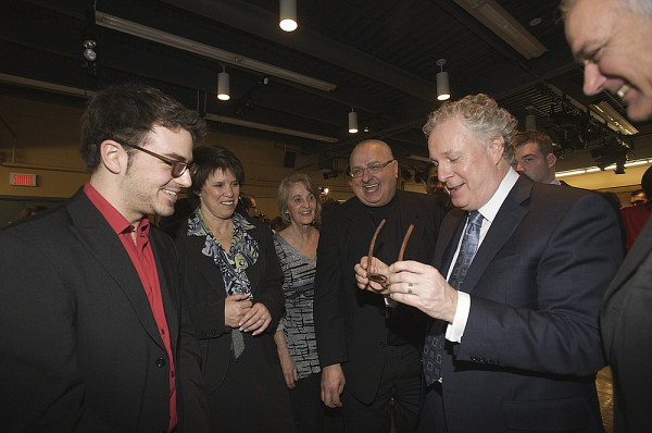 Sous le regard de la rectrice, Jean Charest essaie des lunettes con&ccedil;ues par Julien D&eacute;nomm&eacute;, &eacute;tudiant &agrave; la Facult&eacute; d'administration.