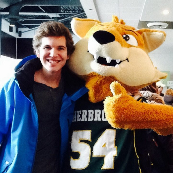 Un visiteur se fait prendre en photo avec Sherlo, la mascotte officielle du Vert et Or!