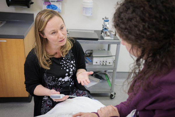 Pr. M&eacute;lanie Morin, talking with a patient.