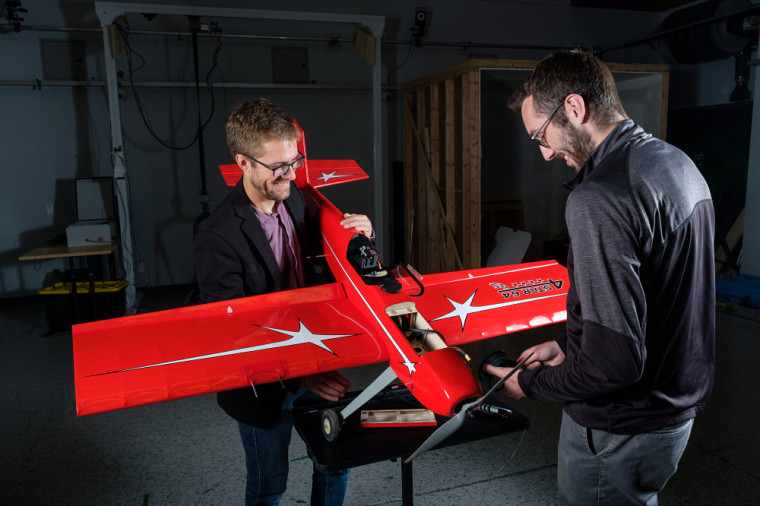 Le professeur David Rancourt en compagnie de son étudiant Samuel Quenneville, étudiant à la maîtrise en génie mécanique, et le drone de type avion.