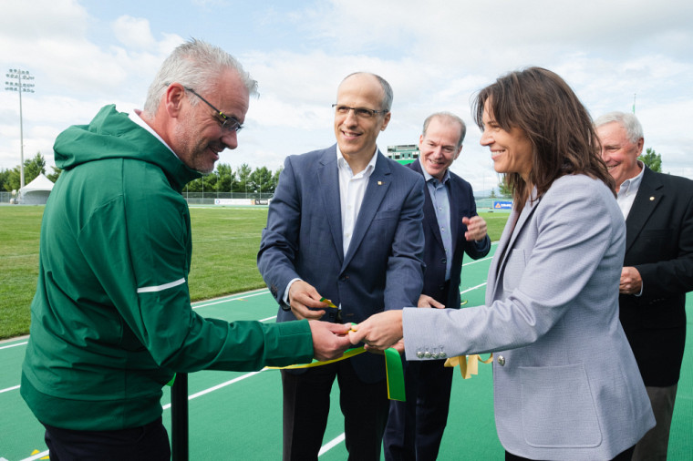 La ministre Charest offre une partie du ruban inaugural à Luc Lafrance, entraîneur du groupe de lancers du Vert & Or et du Club d'athlétisme de Sherbrooke. 