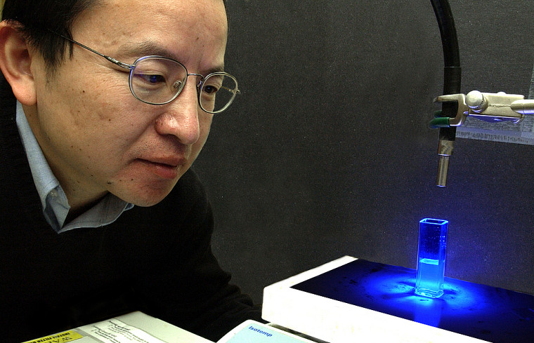 Le professeur Zhao observe une solution photosensible.