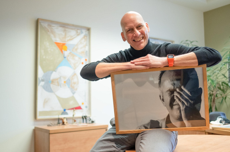 Claude Villeneuve tient un portrait de son défunt conjoint, Alain Harvey.