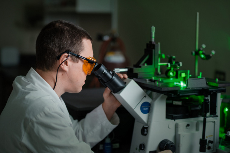 M. Patrick St-Pierre, professionnel de recherche, au microscope ayant servi lors de la recherche. Le laser est utilisé pour stimuler la fluorescence.