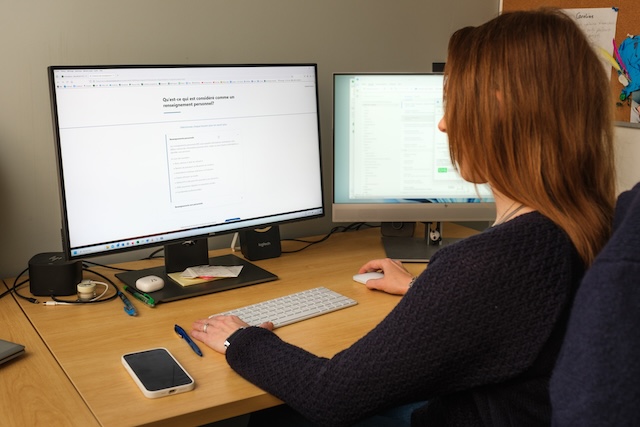 Employée à l'ordinateur avec deux écrans