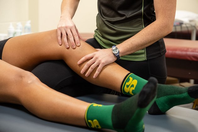 athlète qui reçoit des soins sur une jambe