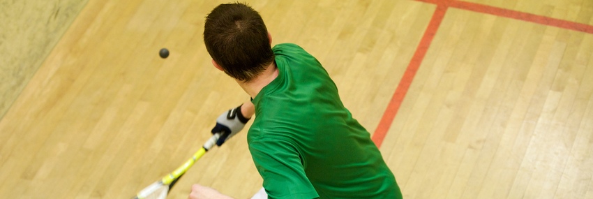 Un garçon joue au squash.