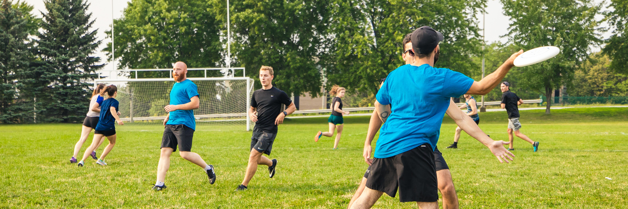 Des personnes jouent au Ultimate frisbee sur le terrain Annexe extérieur du Centre sportif. 