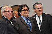 Yves Lamontagne, président du Collège des médecins du Québec, et le doyen Réjean Hébert entourent le porte-parole de la promotion Jean-Christophe Carvalho.